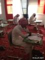 معلِّم بثانوية علي بن أبي طالب  يقدِّم القهوة والتمر لطالب في قاعة الاختبار